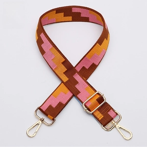 Detail of wide adjustable shoulder strap with pink and orange geometric pattern and gold hardware