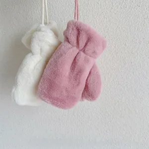 Close-up of soft plush kids neck-hanging gloves in creamy white and dusty pink colors