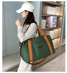 Detail of dark green fitness bag with orange straps and Hayun logo in a lifestyle setting
