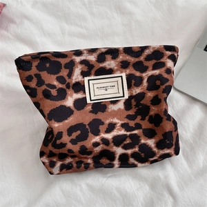 Dettaglio della trousse in tela leopardata su tessuto bianco con bordo del laptop