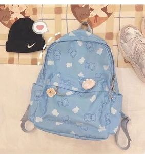 Detail showing light blue canvas backpack with bear prints and decorative pendants