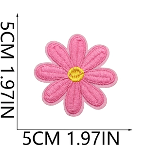 Macro detail of a 5cm pink daisy embroidered patch with yellow center and fine stitching
