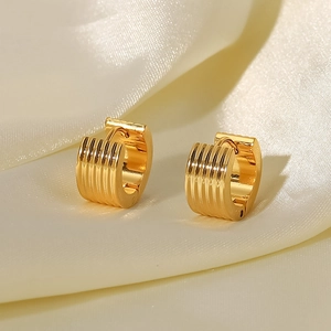 Polished 18K gold plated stainless steel ribbed hoop earrings on silk background