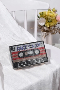 Close-up of retro cassette tape clutch bag with multicolor rhinestones and A Party Mix text