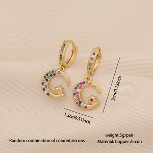 Detailed view of gold star and moon earrings featuring micro-pave rainbow cubic zirconia