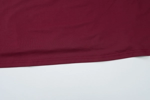 Close-up of deep burgundy dress showing double-stitched hem and fine jersey fabric texture