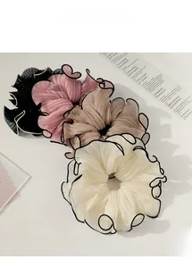 Detailed view of oversized pleated chiffon scrunchies in black, pink, and beige tones