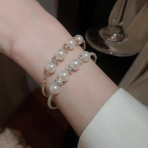 Detail of layered pearl bracelets with diamond spacers in a French vintage style