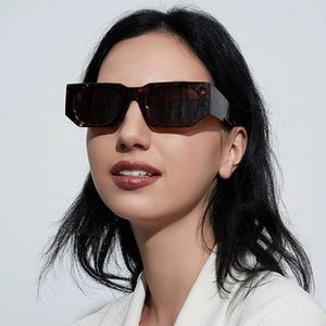 Detailopname van een rechthoekige schildpad zonnebril op een model met donkere glazen