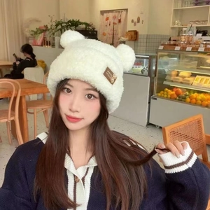 Detail of warm white plush knit hat with cute bear ears in a natural cafe setting