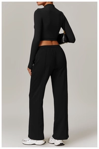 Rear view of tight-fitting black long sleeve crop top with high waist yoga pants