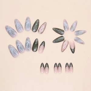Detail of long almond press-on nails with olive green cat eye and pink floral designs