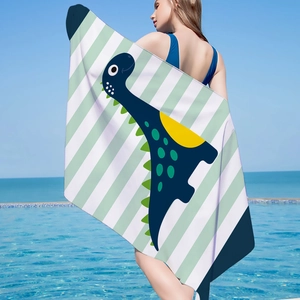Detailed view of green and white striped beach towel with dark blue cartoon dinosaur pattern