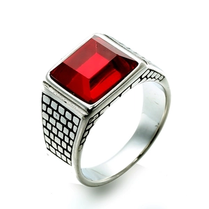 Detailed macro shot showing a rectangular red gemstone on a silver band with grid patterns