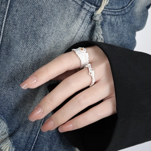 Irregular textured silver ring set with inlaid stones in an organic aesthetic style