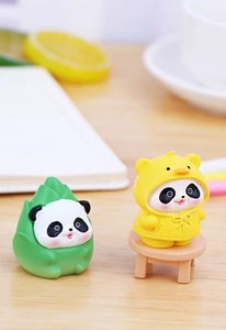 Close-up of cute resin pandas in bamboo and duck raincoat outfits on a desktop