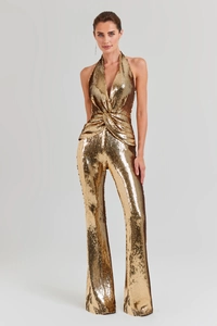 Detail of the twisted waist and sequin texture on the gold halter neck jumpsuit