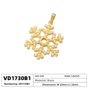 Macro shot of snowflake pendant in gold brass with white pearls, size 22mm x 32mm