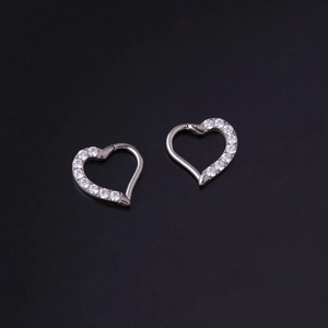 Dettaglio ravvicinato di orecchini in titanio G23 a cuore color argento con inserti in zircone