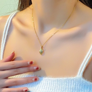Elegant gold titanium leaf pendant necklace for women shown on a model for daily style