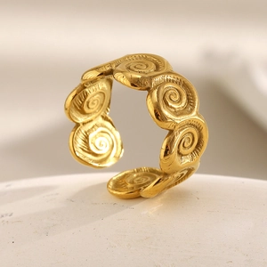 Macro detail of 18K gold plated conch spiral pattern on adjustable stainless steel ring