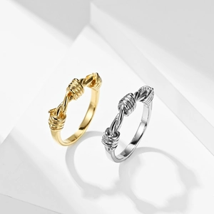 Detail of interlocking knot design on gold and silver stainless steel rings on cubes