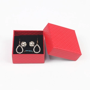 Detailed top view of a red textured jewelry gift box with earring and ring set inside