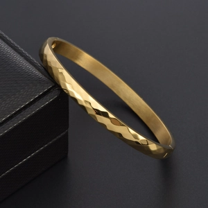 Detailed view of golden titanium steel bracelet with faceted diamond cut surface and clasp