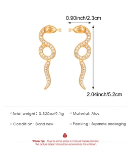 Detailed view of gold snake earrings with rhinestone inlay, dimensions 2.3cm by 5.2cm