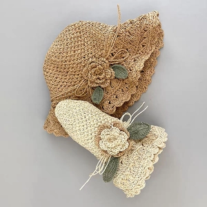 Handmade woven straw sun hat for children with crochet flower detail in natural colors