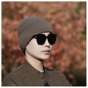 Close-up of brown ribbed knit beanie hat showing warm texture and elastic material