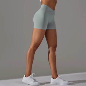 Dettaglio dei pantaloncini yoga senza cuciture a vita incrociata in verde salvia