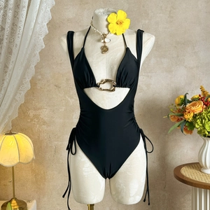 Detail of black halter monokini featuring cutout design and gold ring hardware