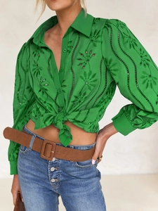Detail of green embroidered button-down blouse with puff sleeves and tie-waist styling