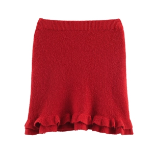 Detailed close-up of red knit skirt featuring an elegant ruffled wavy hemline detail