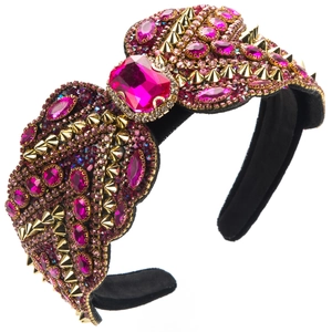 Détail macro du bandeau large en velours avec gemmes fuchsia et pointes dorées punk