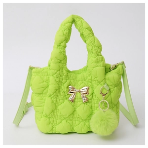 Detail of bright green quilted cloud handbag with gold bow and matching pompom charm