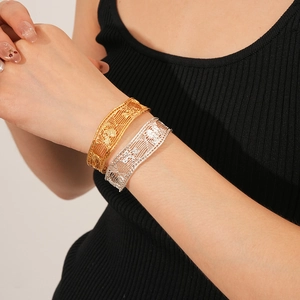 Macro detail of intricate hollow filigree pattern on gold and silver plated mesh bracelets
