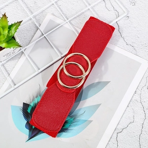 Detail of red elastic waist belt with double gold rings buckle on marble background