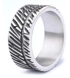 Close-up of wide silver textured ring showing leaf vein patterns and polished finish