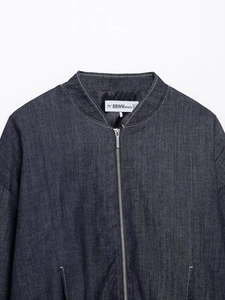 Detailed view of dark indigo denim bomber jacket neckline with high-quality metal zipper