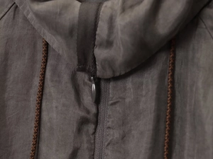 Detailed macro view of twill fabric texture with metal zipper and woven drawstring cord