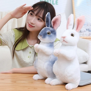 Detail of gray and white realistic bunny plush dolls in a soft indoor lighting setting
