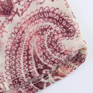 Close-up of red paisley print fabric showing detailed weave and clean stitched edge