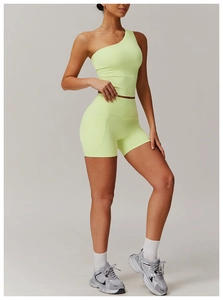 Détail d'un ensemble de yoga vert néon avec haut asymétrique et short à poches