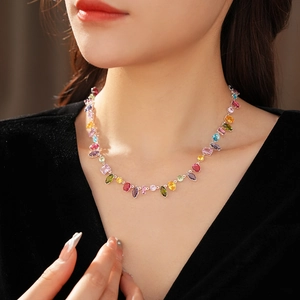Detailed view of colorful zircon drop pendant necklace worn on a model's neck