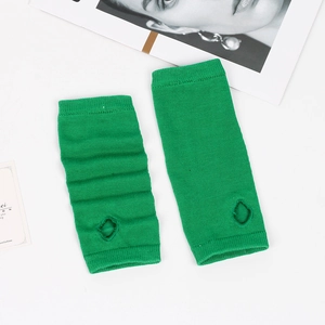 Detail of bright green striped knit arm warmers with thumb holes on white background
