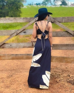 Detail of the backless maxi dress featuring white leaf prints and decorative ties with bows