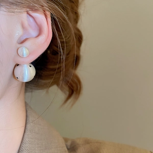 Close-up of double pearl stud earring in matte silver with brushed texture on ear