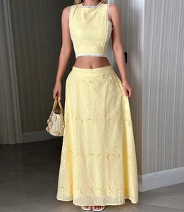 Détail d'un ensemble jupe deux pièces sans manches jaune avec broderie ajourée en dentelle